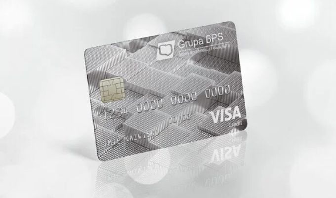 Srebrna karta kredytowa Visa Bussines Credit z logo Grupy BPS, ustawiona pod kątem na jasnym, rozmytym tle.