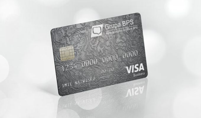 Szara karta płatnicza Visa Bussines z logo Grupy BPS, ustawiona pod kątem na jasnym, rozmytym tle.
