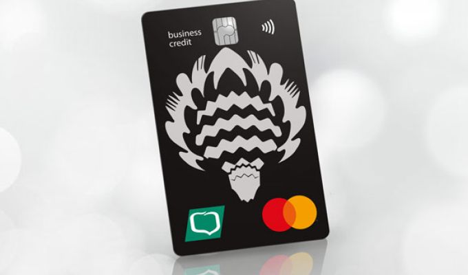 Czarna karta kredytowa MasterCard Business Credit z białym folkowym wzorem oraz z logo Grupy BPS, ustawiona w pionie pod kątem na jasnym, rozmytym tle.